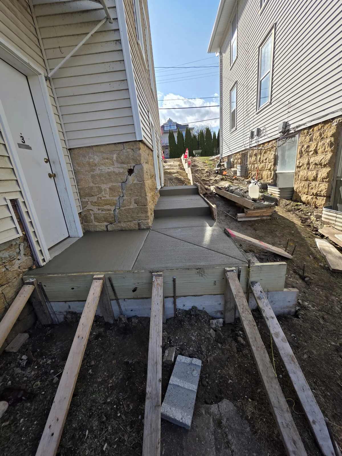 New concrete landing poured inside wood forms at a house entry