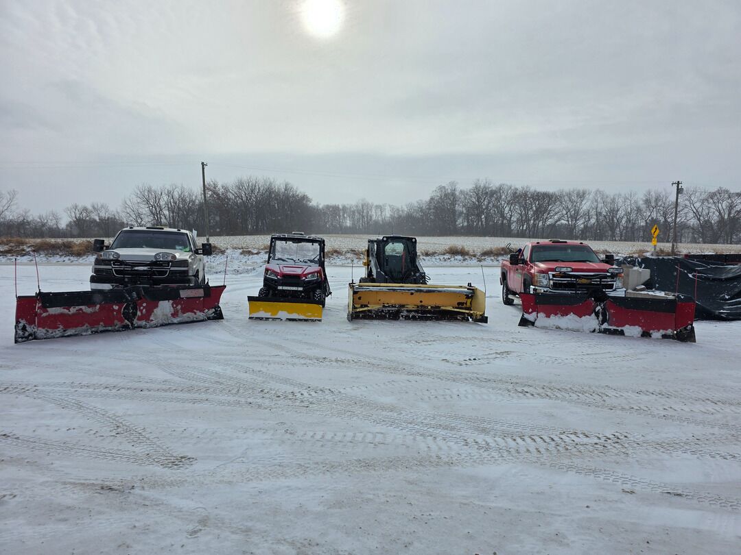Snow removal trucks and equipment lined up on a lot